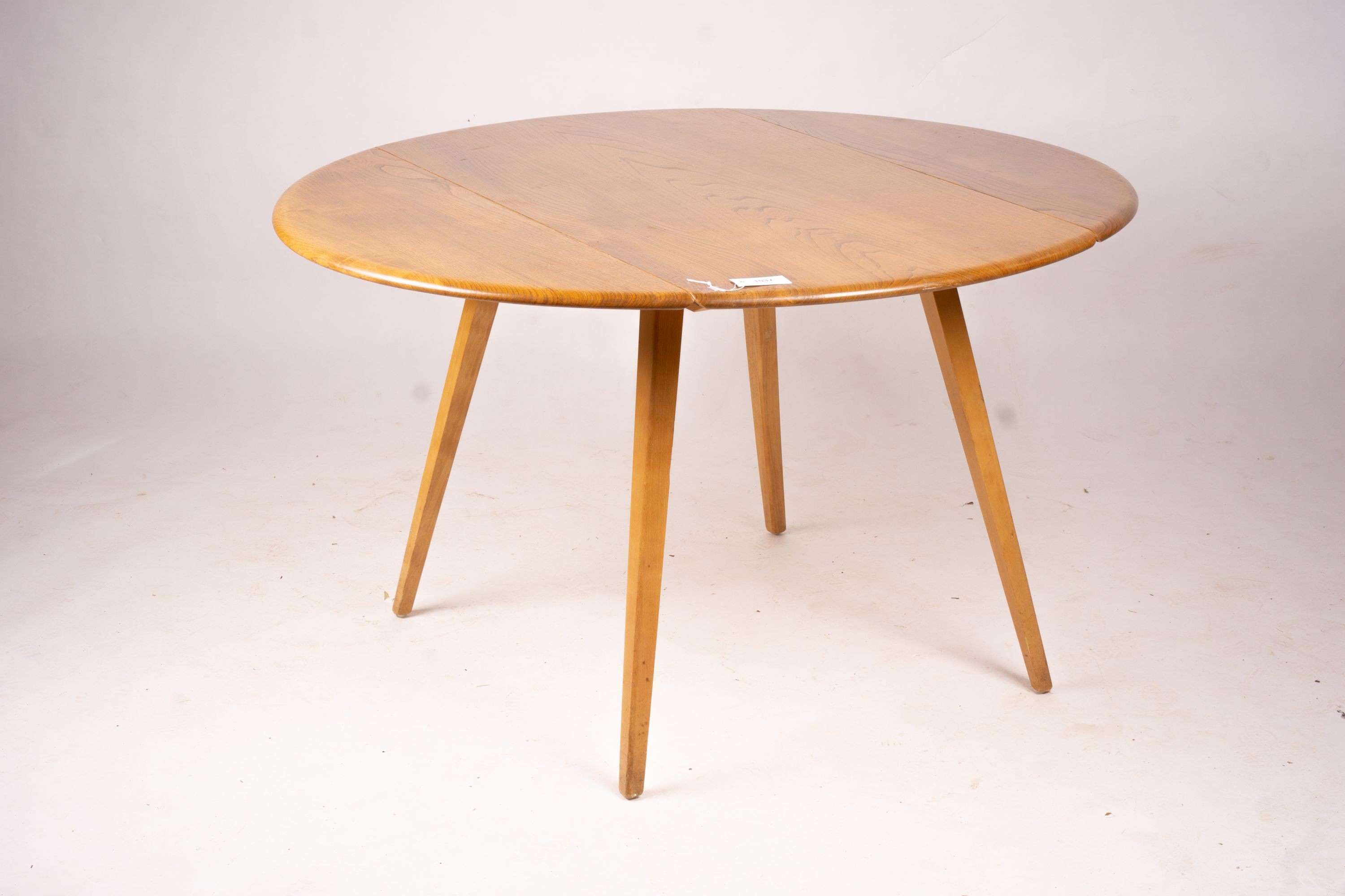 An Ercol light elm and beech circular drop leaf dining table, length 124cm extended, width 113cm, height 72cm